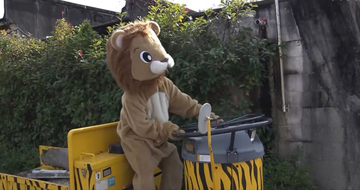 Ein Mitarbeiter in einem Löwenkostüm simuliert einen Ausbruch aus dem Zoo in Japan