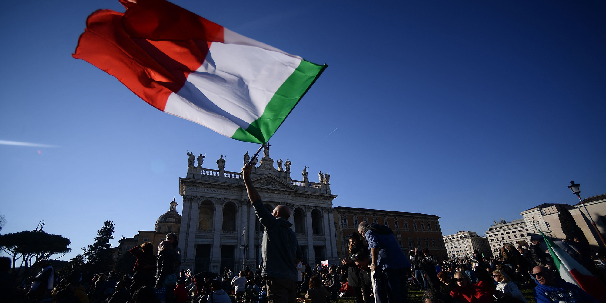 Demonstrant weht italienische Flagge im Zuge einer Demonstration gegen den Grünen Pass